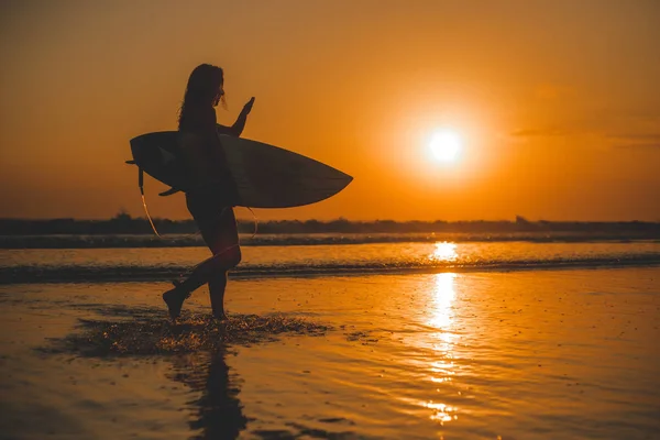 surfer woman with surfboard in sea