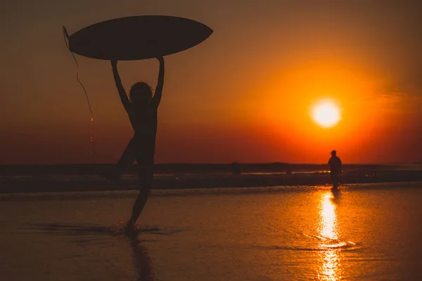 Серфер Женщина Доской Серфинга Над Головой Морская Вода Закат Небе — стоковое фото