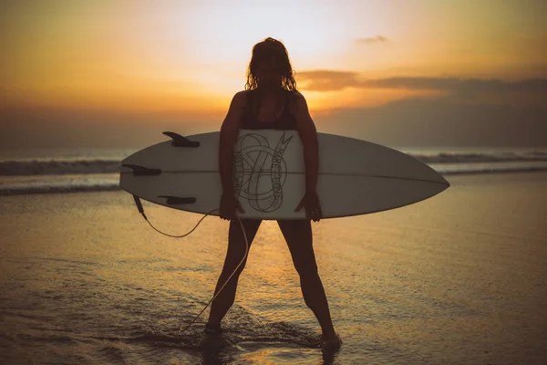 Silueta Ženy Drží Surfovací Prkno Mořské Vodě Při Západu Slunce — Stock fotografie