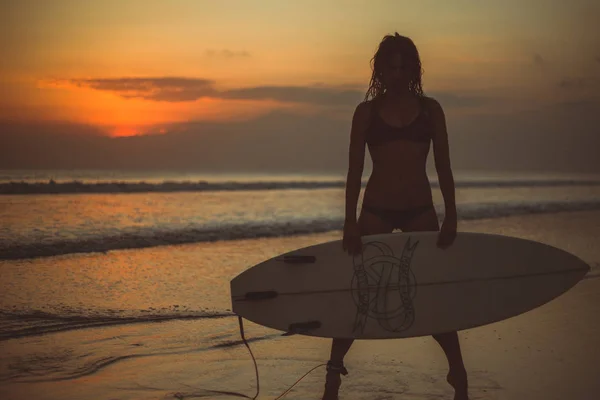 Silueta Ženy Drží Surfovací Prkno Mořské Vodě Při Západu Slunce — Stock fotografie