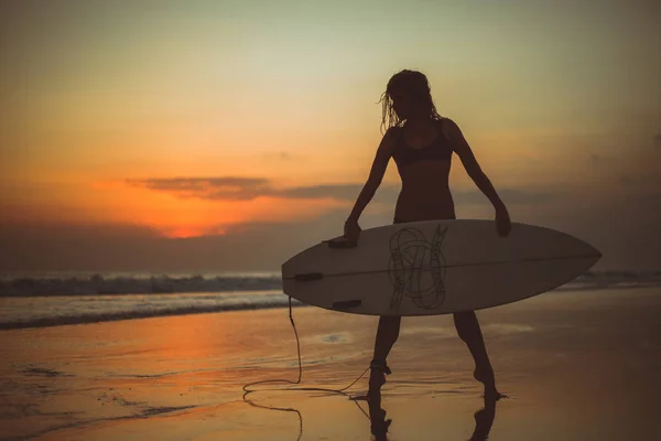 Sportovní Ženy Držící Surfovací Prkno Mořské Vodě Při Západu Slunce — Stock fotografie