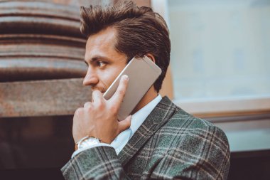 yakışıklı beyaz işadamı duran City cep telefonunda sokak konuşuyor 