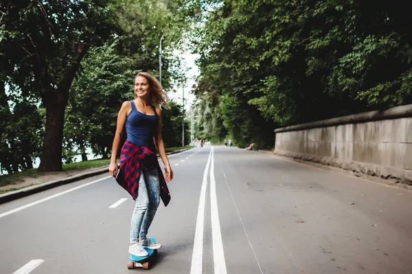 道路でスケート ボードに乗って金髪ティーンエイ ジャーの女の子 — ストック写真