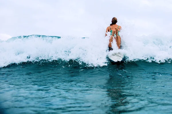 美丽的女孩冲浪者游泳在一块木板在印度洋巴厘岛 — 图库照片