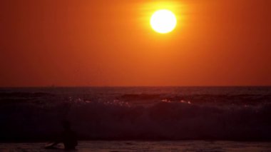 Bali, Endonezya - 25 Mayıs 2020: Rus ve Asyalı sörfçüler Hint Okyanusu 'nun dalgalarında uzun tahtalara biniyorlar, sudan video. Bali, Endonezya