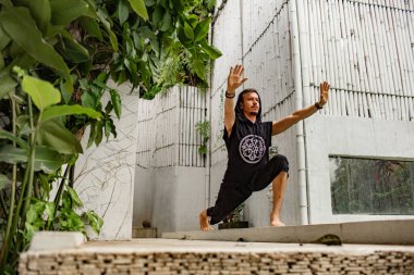 Şaman arka bahçede meditasyon yaparken düşük açılı görüş.