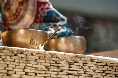 Şamanik uygulama sırasında kokulu sopa ve bakır kâselerin yakın çekim görüntüsü, seçici odaklanma