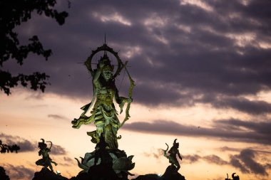 Arjuna heykelinin Sunset Sky, Roundabout, Ubud, Bali, Endonezya 'ya karşı düşük açılı görüntüsü