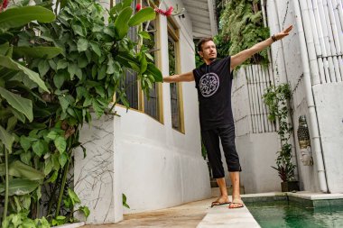 Düşük açılı, havuz kenarında vücut egzersizleri yapan şaman görüntüsü. 