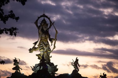 Arjuna heykelinin Sunset Sky, Roundabout, Ubud, Bali, Endonezya 'ya karşı düşük açılı görüntüsü