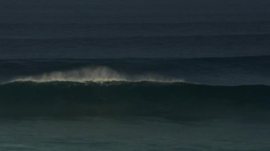 Okyanustaki büyük dalgalarda sörf yapan sörfçülerin yüksek açılı görüntüsü
