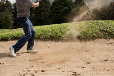 Profesyonel golfçünün kum tuzağından topa vurduğu kesit. Bali. Endonezya.