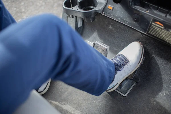 cropped shot of person pressing gas pedal in golf car. Bali, Indonesia