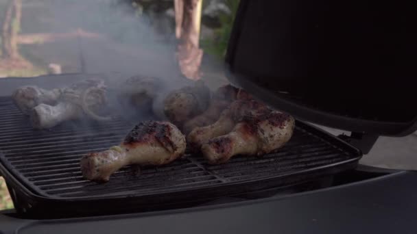 屋外のグリルでおいしい肉を調理する男のクロップドショット — ストック動画