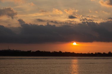 Güzel doğal kıyı manzarası, okyanus ve bulutlu gökyüzü manzaralı günbatımı