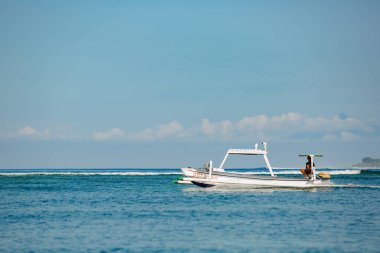Deniz dalgalarında yüzen beyaz tekne. Bali, Endonezya