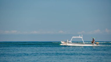 Deniz dalgalarında yüzen beyaz tekne. Bali, Endonezya