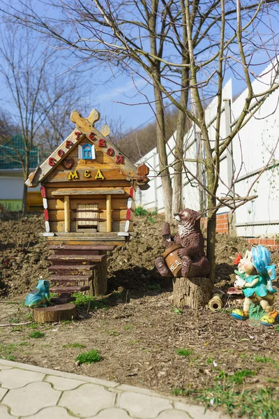 Decorated beehive and garden figures in the apiary. The words \