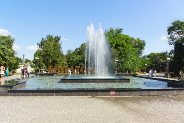 Yevpatoria, Crimea, Ukraine-September 8, 2019: People are photographed near a fountain in Lenin square in the center of the resort city. Evpatoria is written in large letters