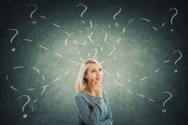 Şaşkın genç kadının bir karatahta önünde deneyin farklı görevler çözmek bir sürü soru sahip. İlham kavramı ve kendini geliştirme.