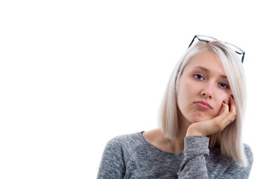 Düz sarı saçlı mavi gözlü altında çene, elini tutarak kameraya bakarak sıkılmış rahatsız güzel kız trendy eyewear bir baş ve uzun kollu kazak giyen portresi.