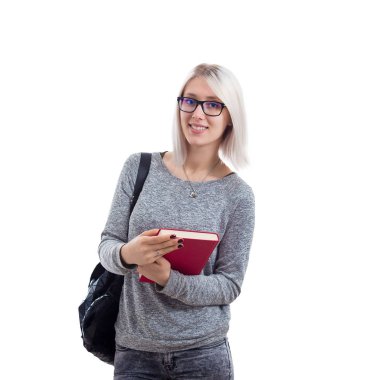 Öğrenci kız gözlük ve elleri üzerinde beyaz arka plan izole kırmızı kitap tutan bir sırt çantası giyiyor.
