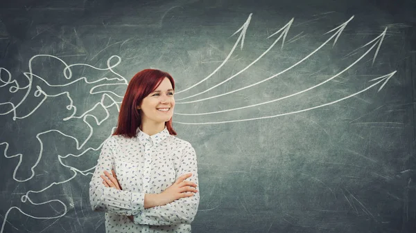 Concept of information processing as a concentrated redhead woman smiling in front of a huge blackboard as mesh lines come through head and transform into straight arrows as project ideas.
