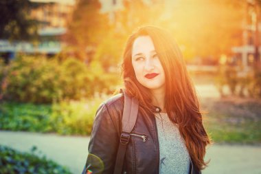 Genç kadın öğrenci portresi Üniversitesi Bahçe, sonbahar günbatımı zamanı.