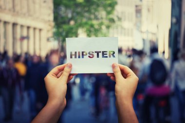 Hipster metin ile bir beyaz kağıt levha bir kalabalık şehir sokak arka plan üzerinde holding eller. Yaşam tarzı kavramı, açık macera seyahat. Yeni eğilimleri bağımlılığı, moda sanat.