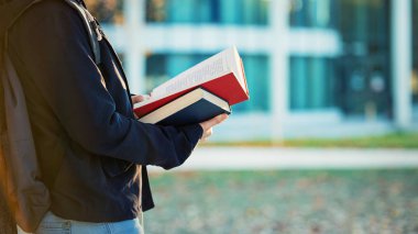 Yan görünümü yaşam tarzı portresi öğrenci kitap okumak, açık havada Üniversitesi Kampüsü arka plan kopya alanı ile yakından.