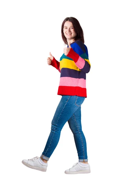 全长侧视图描绘的年轻女子在走路时露出大拇指的手势 对着镜头微笑 正面象被隔绝的标志在白色背景 — 图库照片