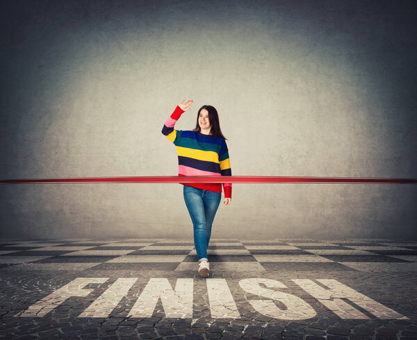 Победившая молодая женщина, широко улыбающаяся, широко празднует поднятую ладонь, здоровается с друзьями. Случайная девушка пересекла финишную черту, сломала красную ленточку. Победа, мотивация и концепция успеха
.