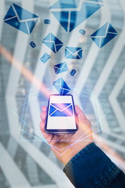 Adam el kot ceket bir cep telefonu ekran arayüzü çıkıyor olarak iletileri gönderme tutarak. Zarf iletisi hologram simgesi. Modern teknoloji kavramı sanal gerçeklik sosyal yaşam.