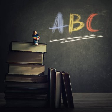 Blackboard yazılı metin Abc harfleri tebeşir ile seyir büyük kitap yığını üstünde gerçeküstü görünümü genç kadın öğrenci oturma rahat. Uygulama öğretim eğitim ve bilgi kavramı.
