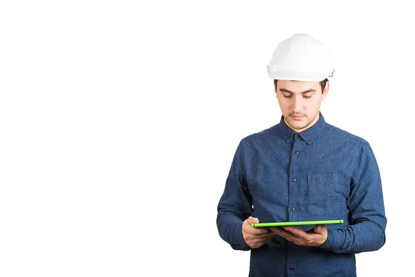 白い背景に分離されたタブレット コンピューターを使用して保護ヘルメットを身に着けている自信を持って若い男性エンジニア — ストック写真