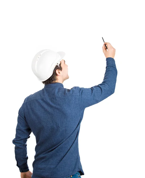背面ビュー若者エンジニア リング身に着けている保護用のヘルメット鉛筆コピー スペースと白い背景上の孤立した図面 — ストック写真