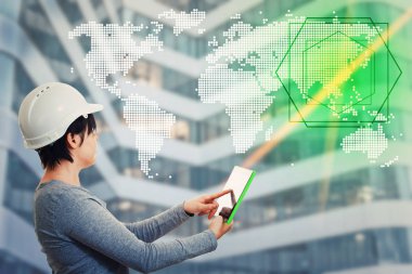 Kendine güvenen genç kadın giyiyor koruyucu kask tutarak hedef seçerek bir dünya harita hologram görüntülemek için Gadget'ı kullanarak pc tablet bilgisayar mühendisi. Dijital ekran arayüzü, devam eden mühendislik.