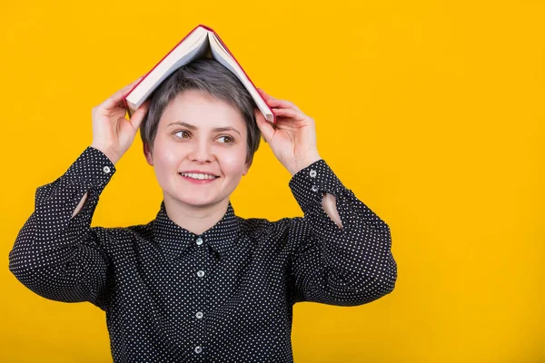 Woman with book on head — Stock Photo, Image