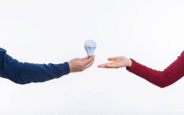 Elektrik mühendisi modern ampul tasarrufu enerji veren. Erkek el kadınların gelecekteki enerji sorunlarına çözüm bir elektronik enerji tasarruflu cihaz gösteren. Enerji tasarrufu konsepti.