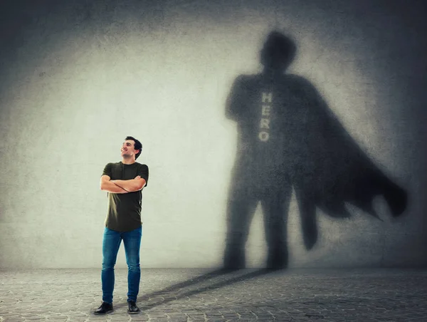 Hombre lanzando un superhéroe con sombra de capa en la pared — Foto de Stock