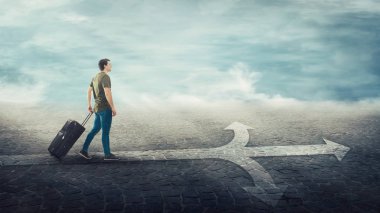 Adam gezgin onun haddeleme bavul taşıyan, bir crossro üzerinde yürüyor