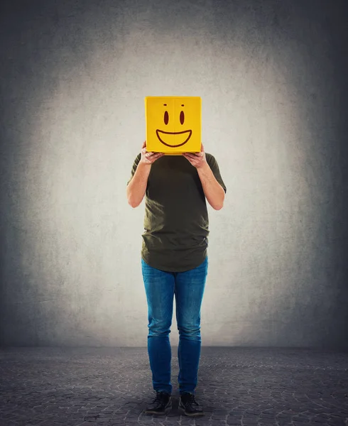 Persona de incógnito sosteniendo una caja amarilla en su lugar cabeza. Introvertir un —  Fotos de Stock