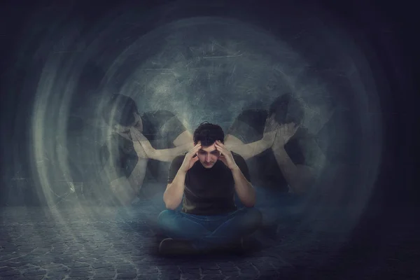 Man seated on the floor, hands to head, suffer split emotions in — Stock Photo, Image