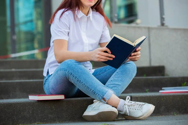 Jovens estudantes sorridentes ao ar livre segurando livros — Fotografia de Stock