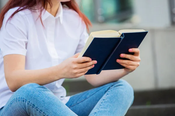 Um estudante confiante segurando livros sobre backg edifício universitário — Fotografia de Stock