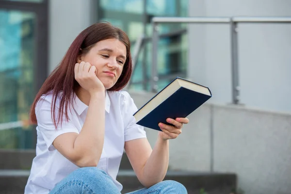 疲惫的学生女孩拿着一本书 — 图库照片