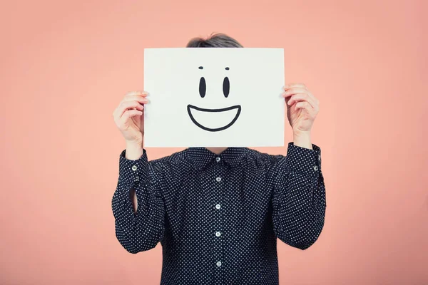 Mujer de negocios cubriendo la cara usando una hoja de papel blanco con sonrisa — Foto de Stock