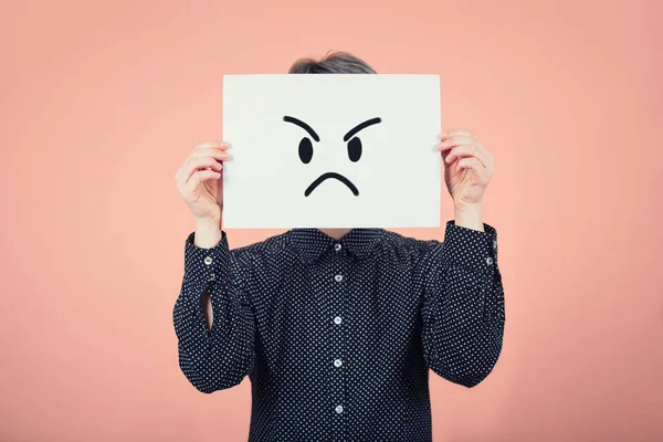 Businesswoman covering face using a white paper sheet with angry