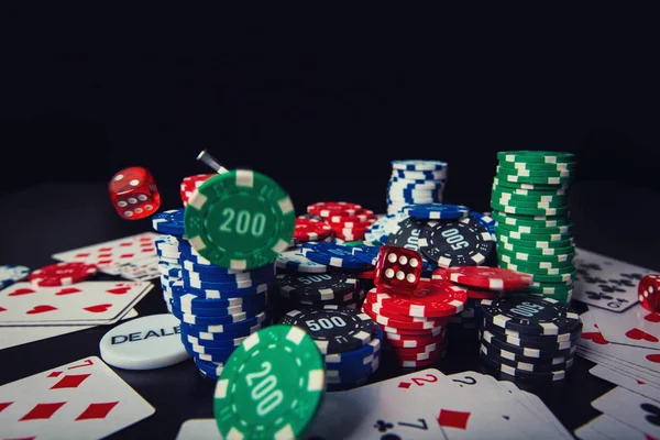 poker chips, playing cards and dices isolated over black casino