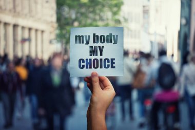 Feminist eller mesajı ile bir protesto afiş tutan bedenim